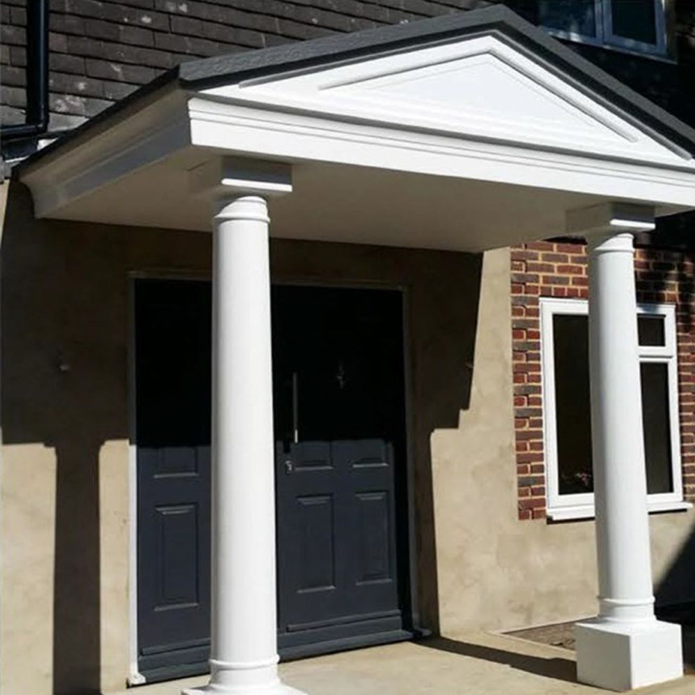 Front entrance of a house with white portico and columns and a dark door.