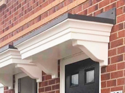 Decorative overdoor canopy attached to a brick wall with a black door below