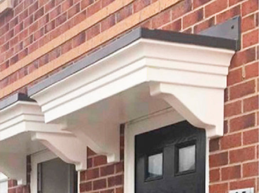 Decorative overdoor canopy attached to a brick wall with a black door below
